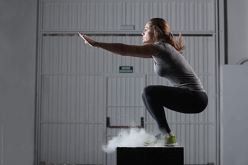 Mulher em forma pulando em uma caixa de ginástica para malhar por Miquel Llonch papel de parede HD