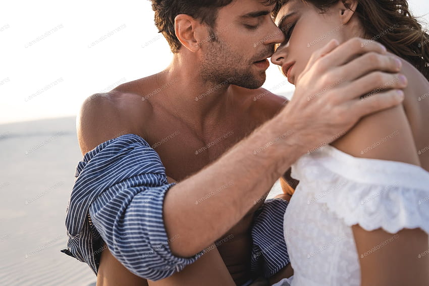 passionate young couple kissing on beach by LightFieldStudios on Envato Elements HD wallpaper