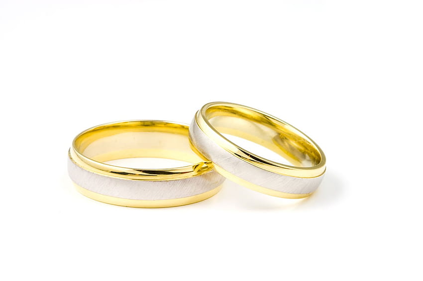 A pair of golden wedding rings on golden background - Stock Image -  Everypixel