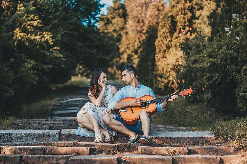 Happy young Vietnamese couple with guitar and basket of food walking in  park Stock Photo - Alamy