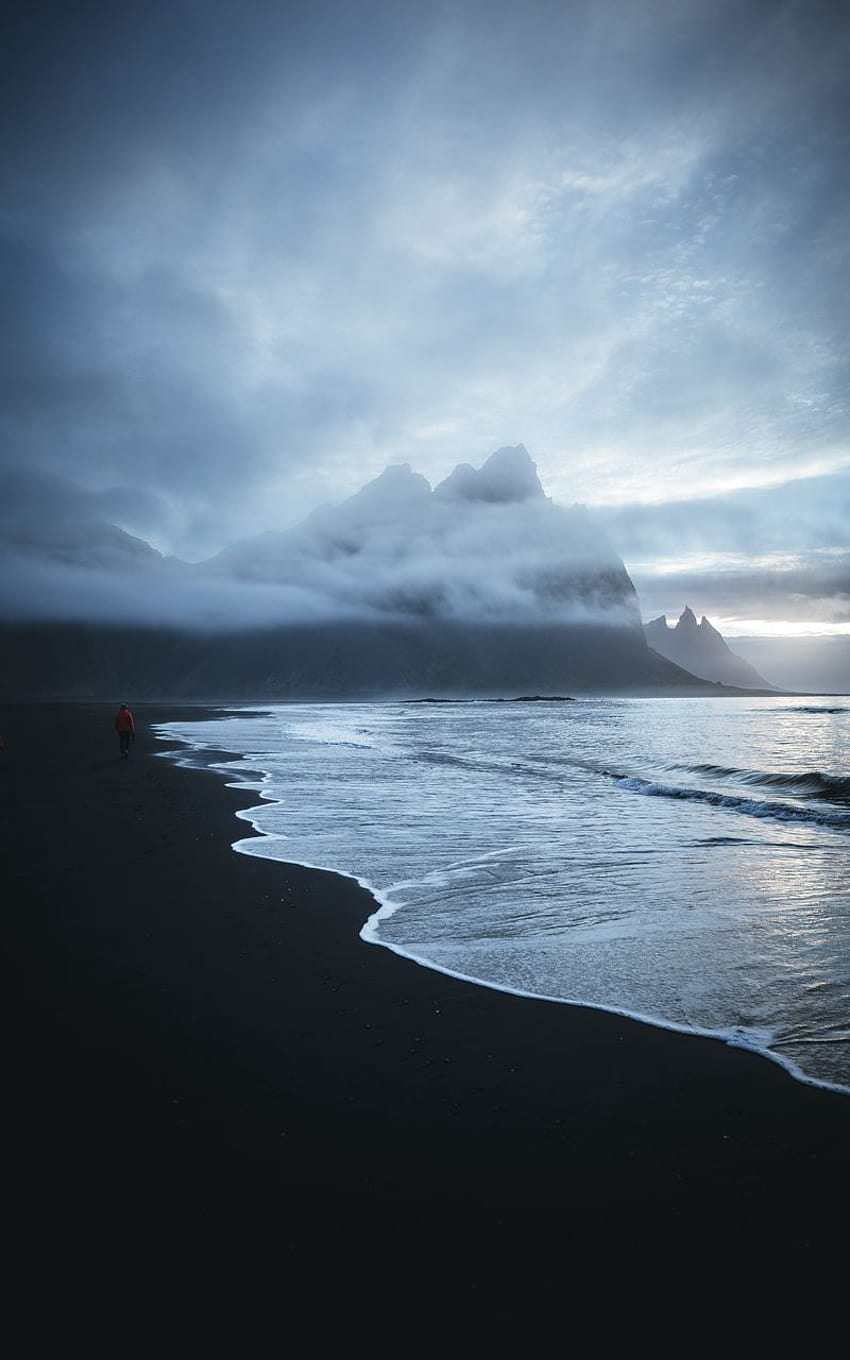 spiaggia sabbia uomo montagne solitario mare nero onda nuvole Sfondo del telefono HD