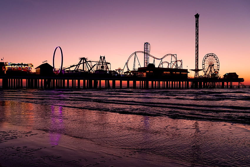 The morning sun silhouettes the Historic Pleasure Pier on the Galveston ...