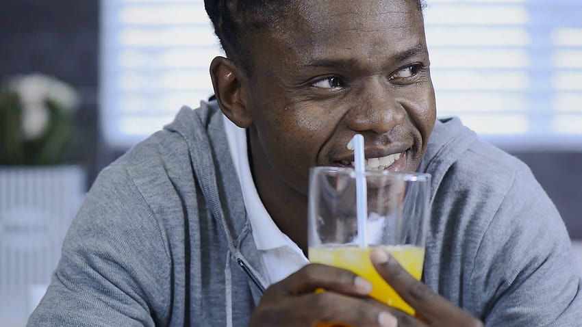 ชายแอฟริกันอเมริกันดื่มน้ำส้มในครัวไลฟ์สไตล์สมัยใหม่ วิดีโอสต็อก ผู้ชายกำลังดื่มน้ำผลไม้ วอลล์เปเปอร์ HD
