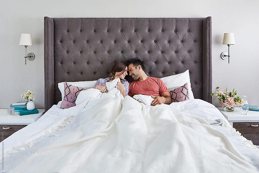 Млада мултиетническа двойка, сгушена в леглото сутрин HD тапет