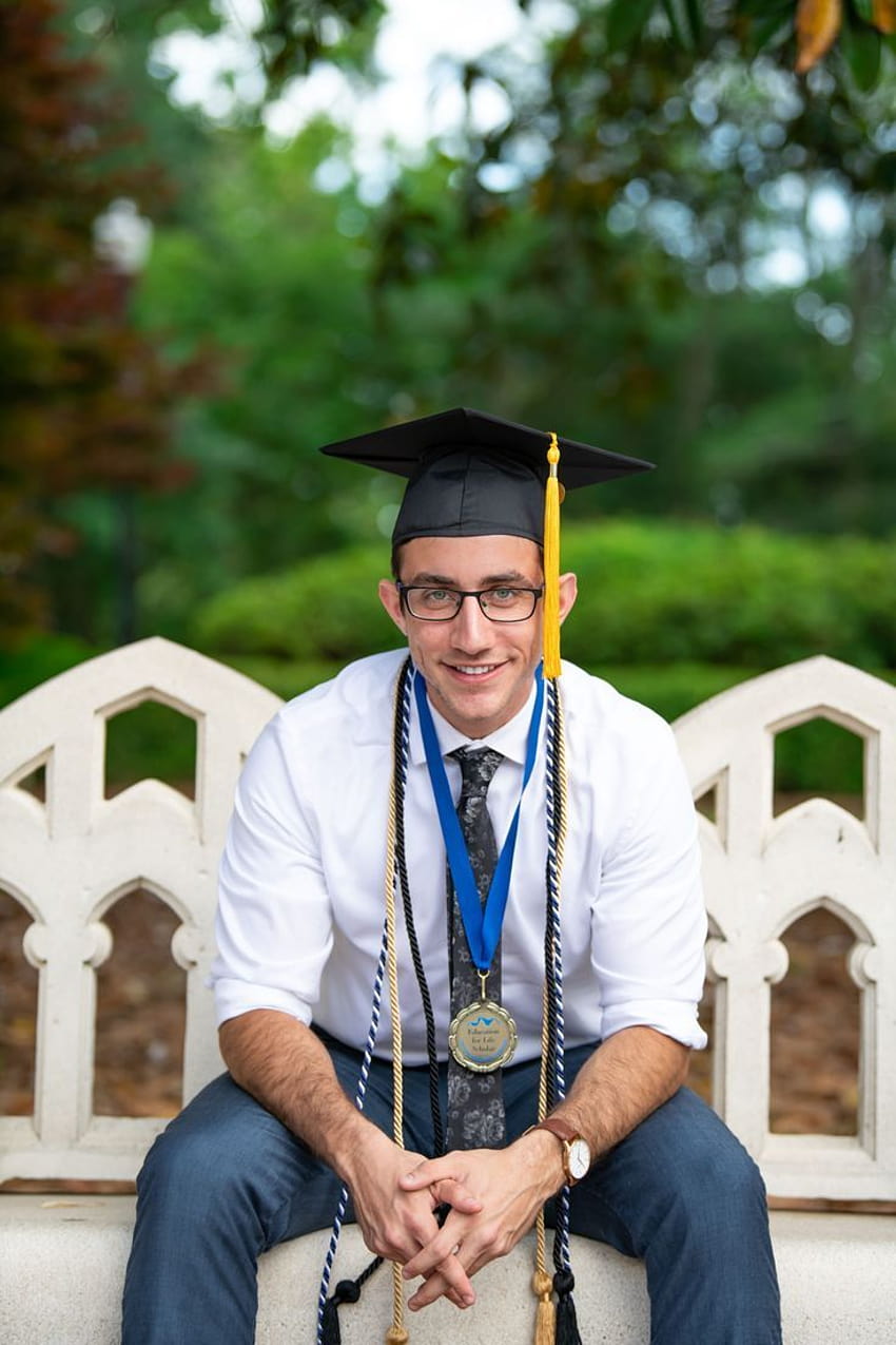 A young male happy graduate poses for his graduation photo Stock Photo -  Alamy