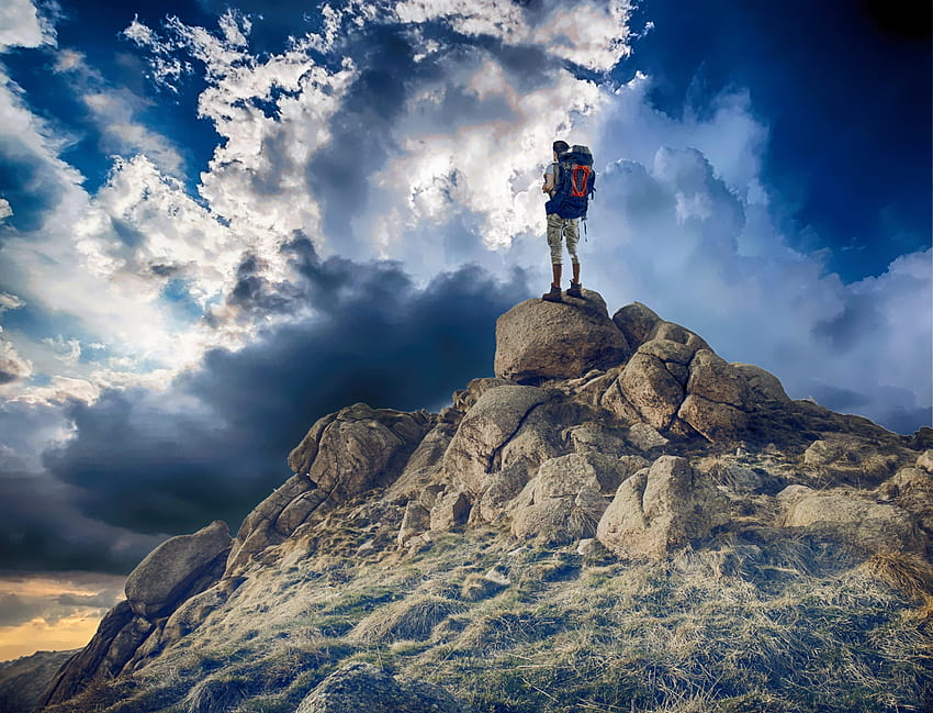 ผู้ชายยืนอยู่บนโขดหินในภูเขาในเวลากลางวัน ปีนเขา วอลล์เปเปอร์ HD