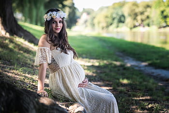 Brunette girl wearing a white dress with a Louis Vuitton b…