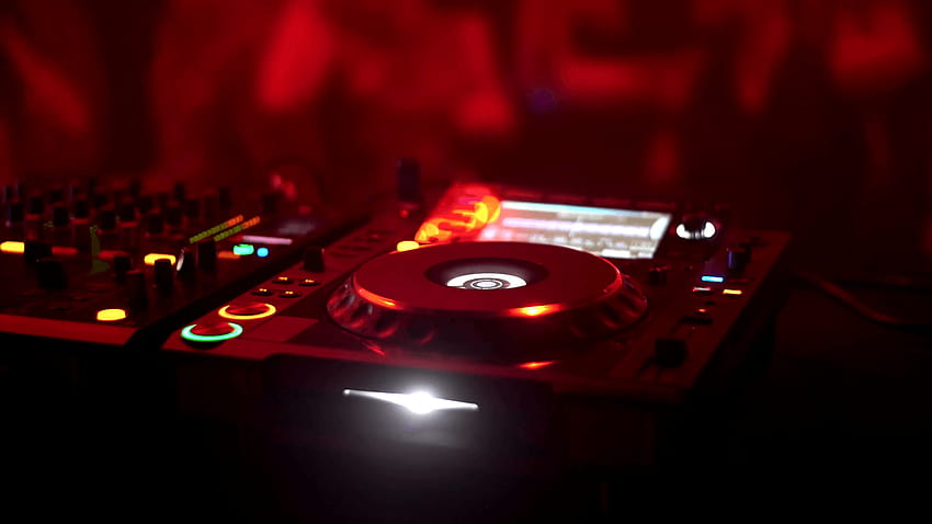 Dj disc jockey miksujący piosenki na swoim gramofonie przy biurku w nocnym klubie, w tle tańca i piosenek Tapeta HD