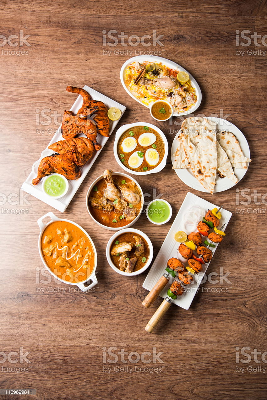 Receta variada de comida india no vegetariana servida en un grupo que incluye pollo al curry cordero masala andaegg curry mantequilla pollo biryani tandoori murg pollo tikka y caldo naanroti fondo de pantalla del teléfono