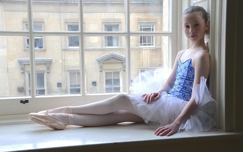 La bambina sveglia della ballerina si siede al lato della finestra, piccola ballerina Sfondo HD