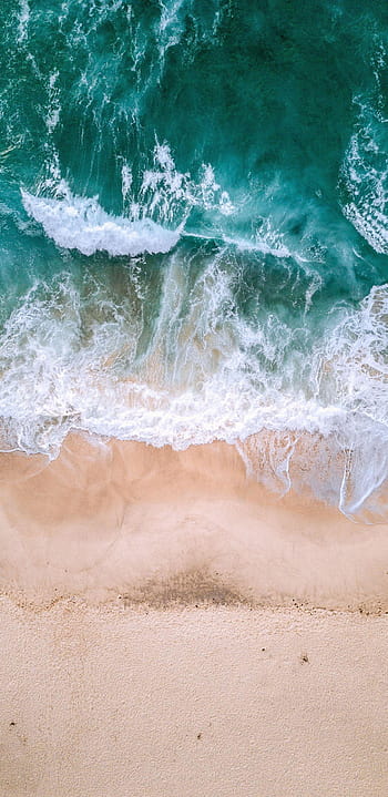 Aerial top down footage of white waves and emerald green ocean water ...