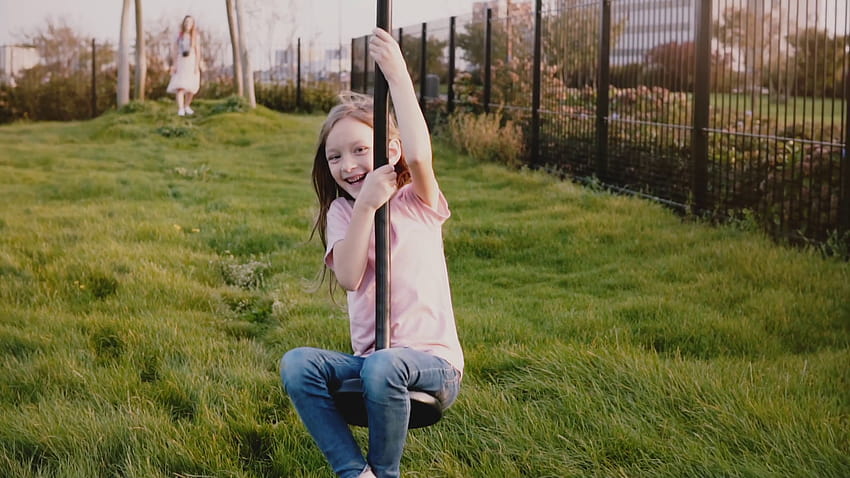 Gadis Kaukasia kecil di zipline taman kota. Gerak lambat. Anak perempuan yang gembira mengendarai kawat zip panjang, tersenyum. Stok Rekaman Video Wallpaper HD
