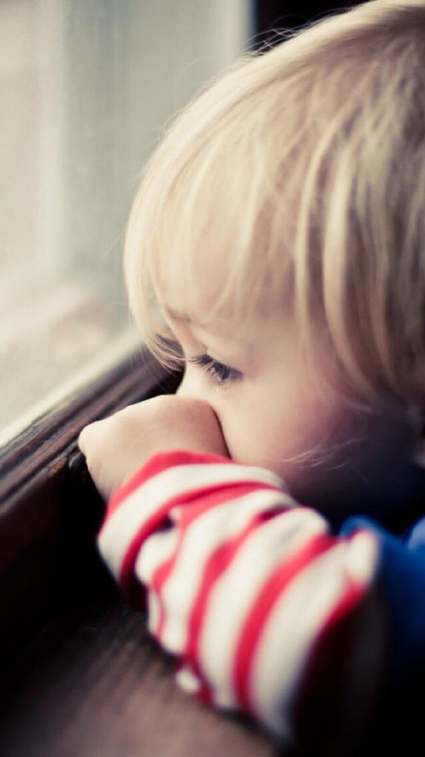 Naiver süßer kleiner Junge, der das Fenster des iPhone 8 beobachtet HD-Handy-Hintergrundbild