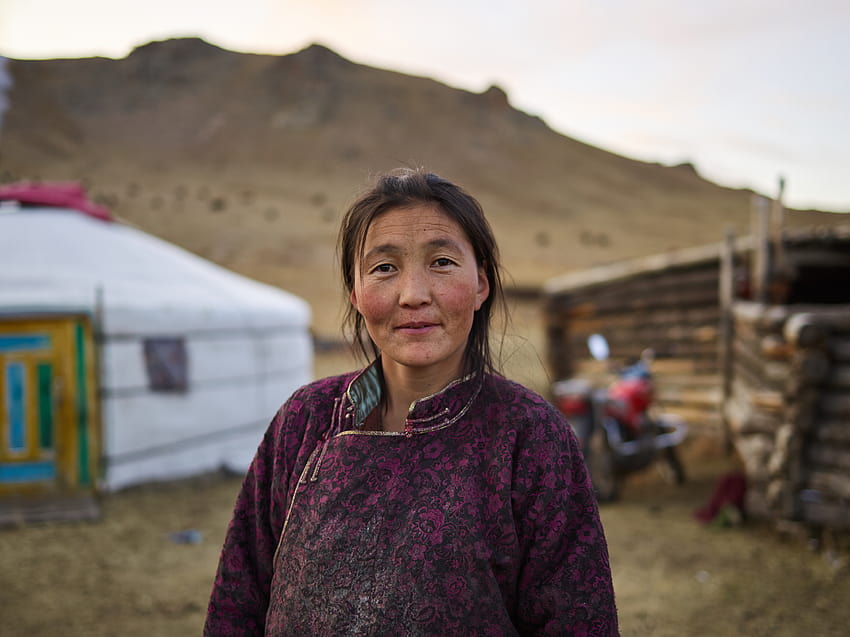 Calm middle aged Mongolian female against yurts in village · Stock HD wallpaper