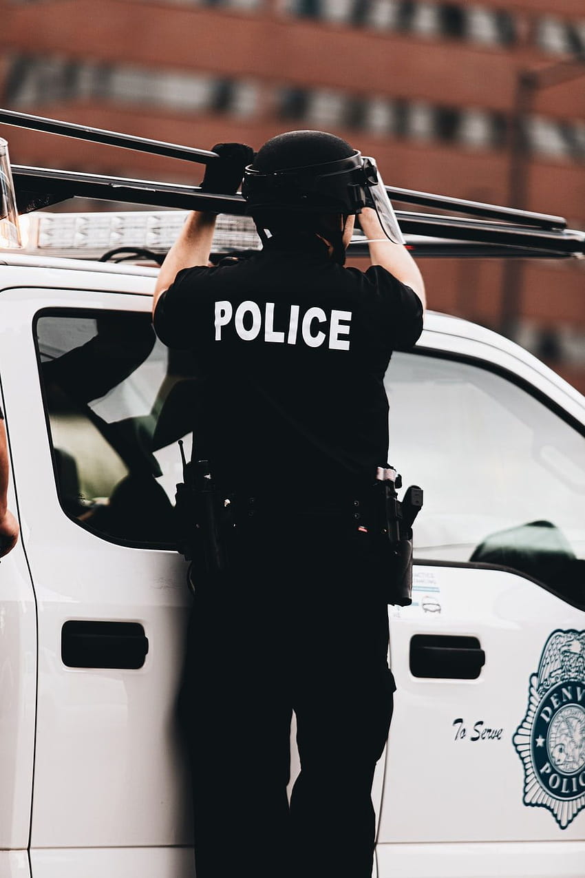 昼間に白い車の横に立っている黒と白の警察の制服を着た男 – 警察のギア HD電話の壁紙