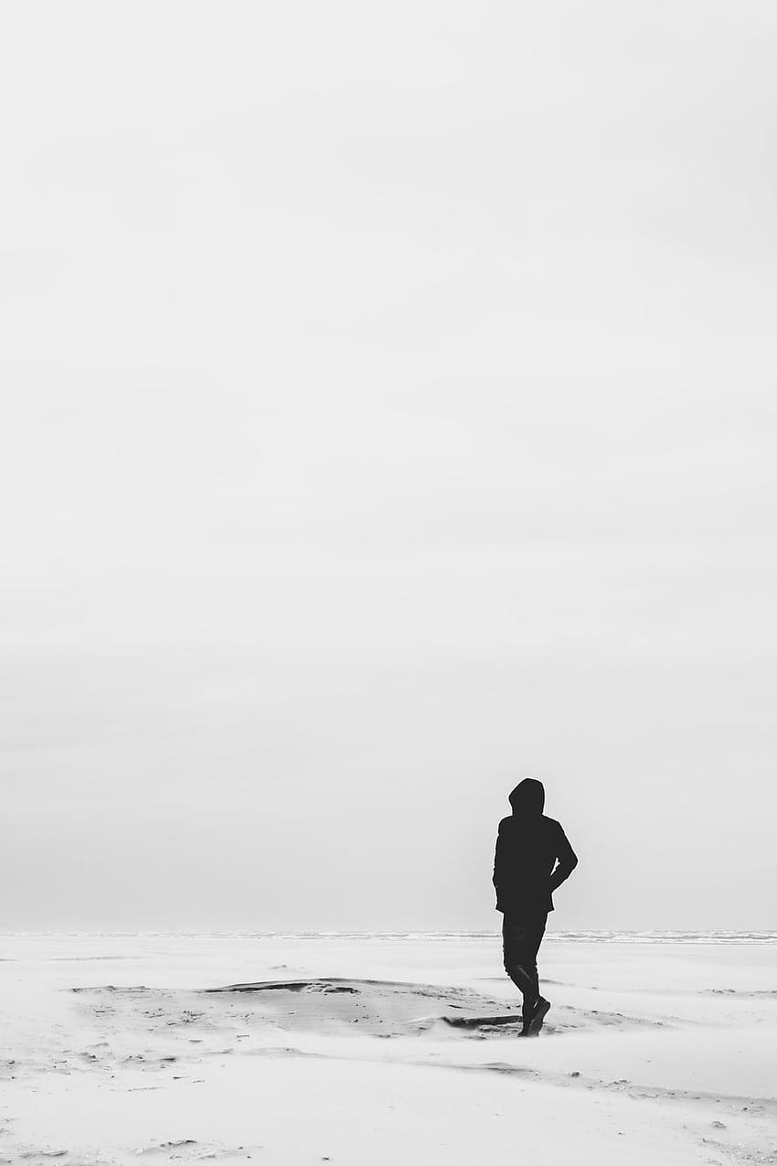 hombre vestido con capucha de pie en el campo cubierto de nieve durante el invierno, solo hombre negro fondo de pantalla del teléfono