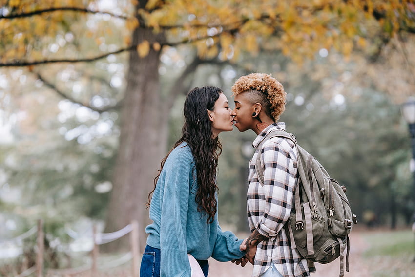 Couple de lesbiennes multiethnique s'embrassant tendrement sur un sentier dans le parc d'automne · Stock, automne lesbien Fond d'écran HD