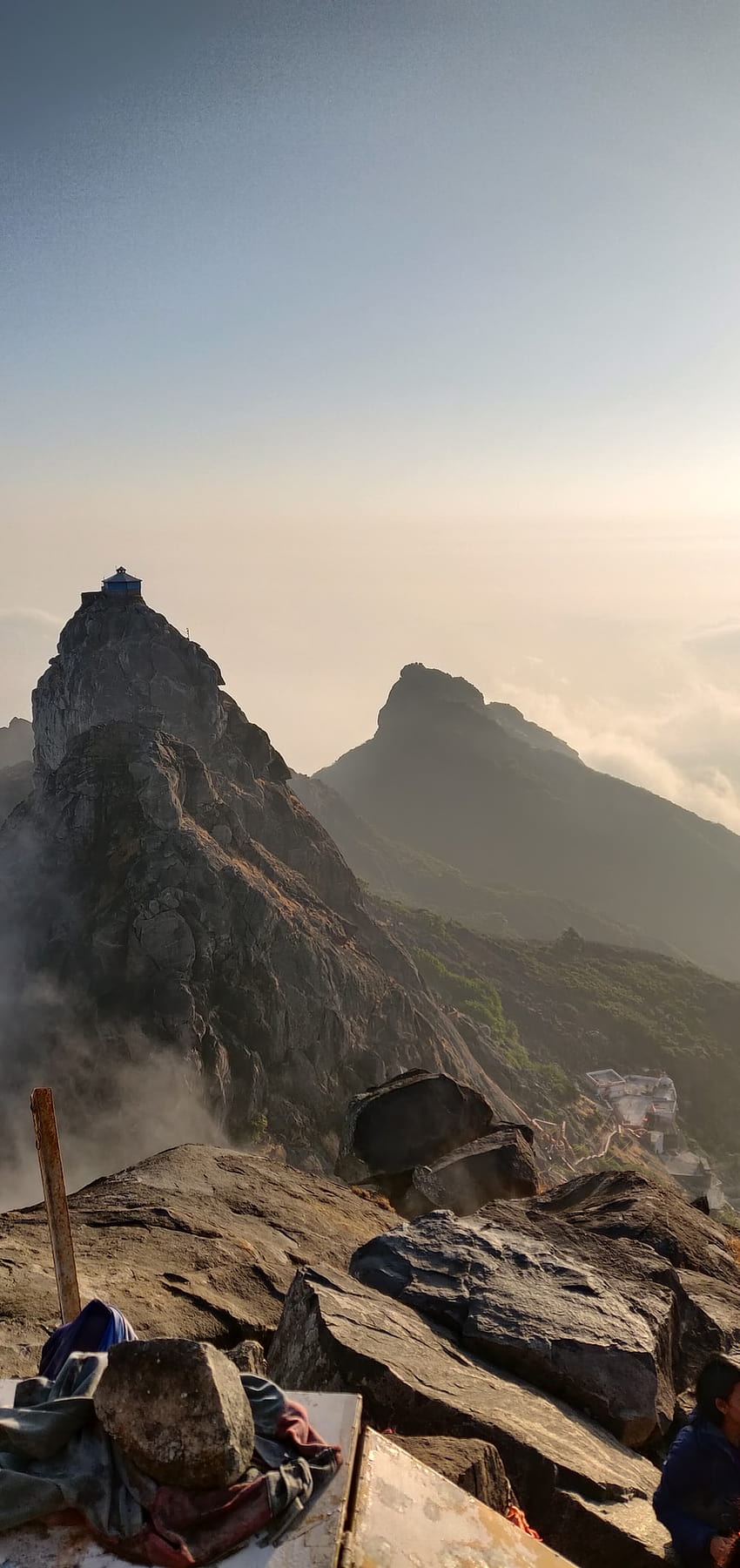 човек, стоящ върху скална формация през деня – Girnar HD тапет за телефон