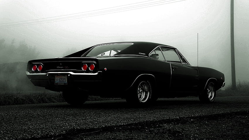 Classic black Dodge Challenger coupe on asphalt road, vintage dodge