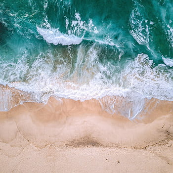 Top aerial view of waves break on tropical yellow sand beach. Bird's ...