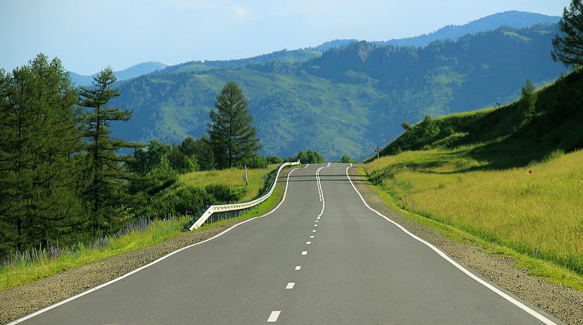 une route déserte autour de collines verdoyantes sur une route ensoleillée Fond d'écran HD