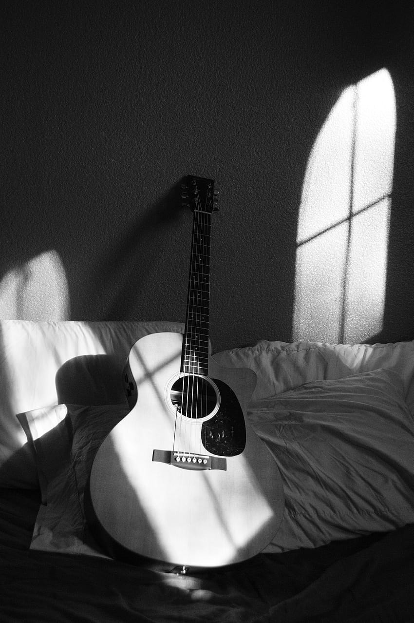 Weiße Akustikgitarre auf grauem und weißem Textil · Schaft, schwarze Gitarre HD-Handy-Hintergrundbild
