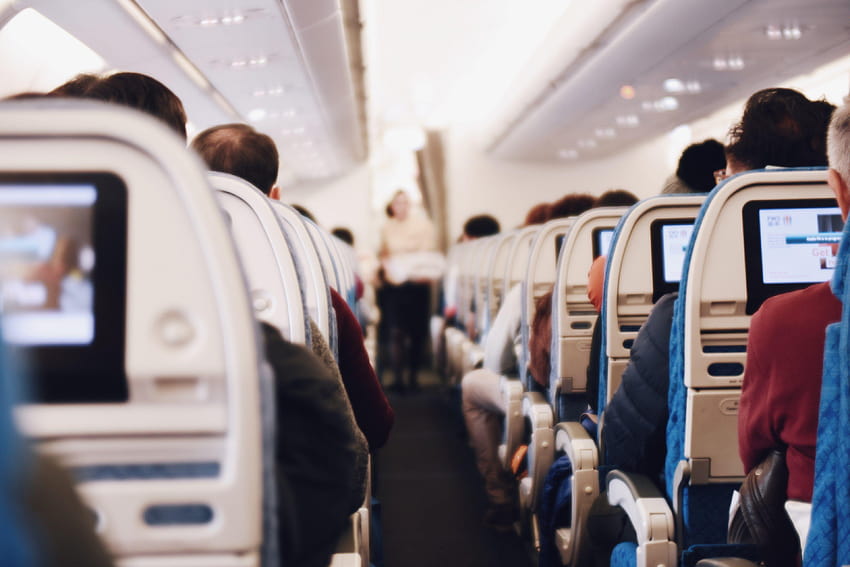 a view of the airplane aisle with a flight attendant carrying a, airplane cabin HD wallpaper