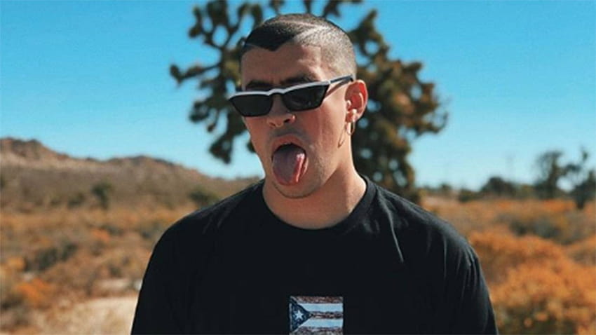 Bad Bunny Aesthetic Is Wearing Black Tshirt Standing In Blur Backgrounds With Tongue Out Music HD wallpaper