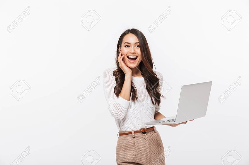 Porträt einer aufgeregten asiatischen Geschäftsfrau, die einen Laptop isoliert über weißem Hintergrund hält. Stock, im Jahr 2020, Geschäftsfrau HD-Hintergrundbild