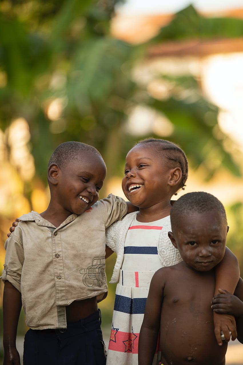 Niños africanos felices abrazándose en la calle · Stock fondo de pantalla del teléfono