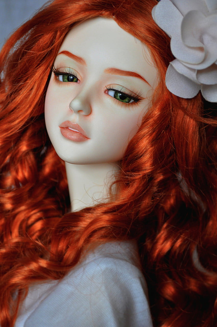 modern makeup doll face portrait toy red hair girl lying in green