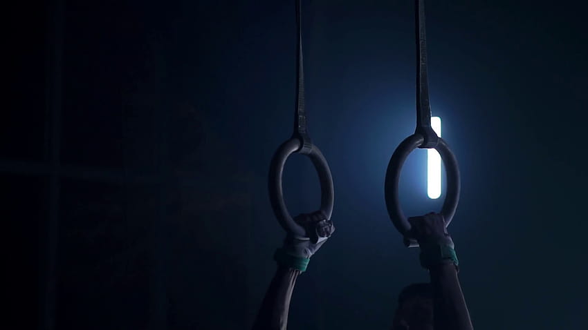 Gymnast on a dark backgrounds stands on his hands using rings in the air. Performs rotation in the Olympic program in slow motion 120 fps. gymnastic rings, professional gymnast Stock Video Footage, ring gymnast HD wallpaper
