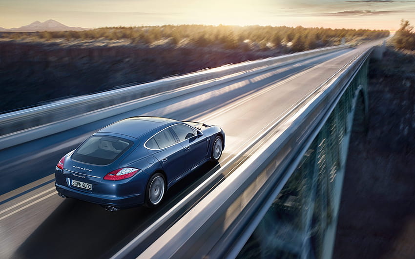 Un automóvil Porsche azul que se ejecuta en un puente alto, debe estar a una velocidad increíblemente rápida, bueno para mirar y conducir: automóviles, conducción a alta velocidad fondo de pantalla
