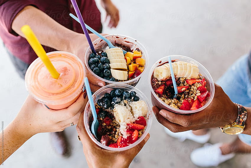 A group of friends holding up their acai bowls together by Kristen Curette & Daemaine Hines HD wallpaper