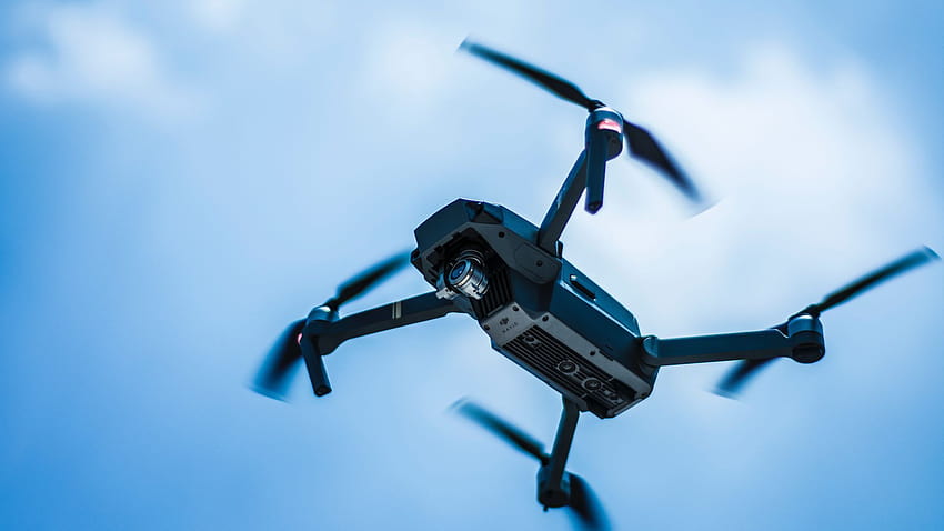 Dron Quadcopter gris en el cielo fondo de pantalla