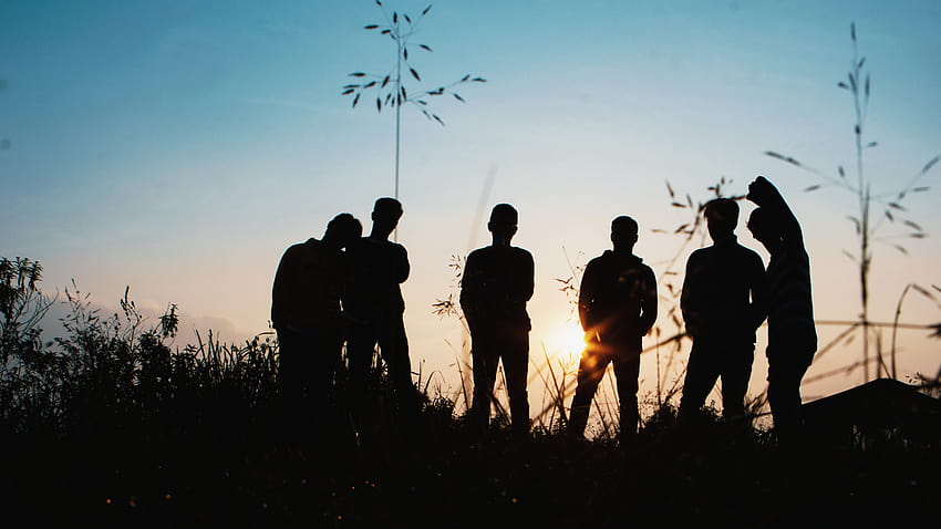 Grupo de silueta de personas de pie en el campo de hierba · Stock fondo de pantalla