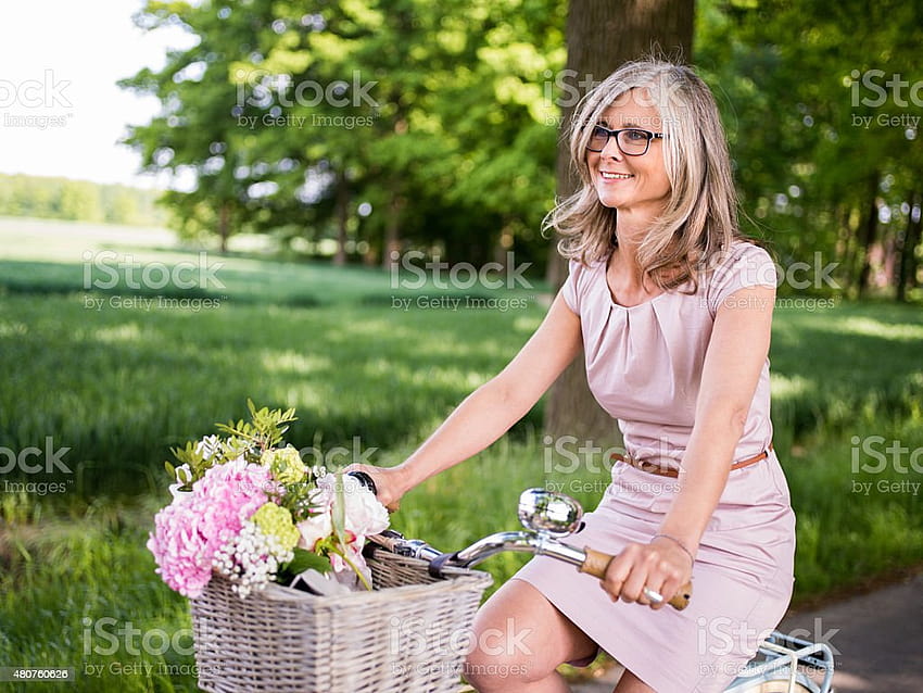 Mature Woman Riding Vintage Bicycle Through A Summer Park Stock ...