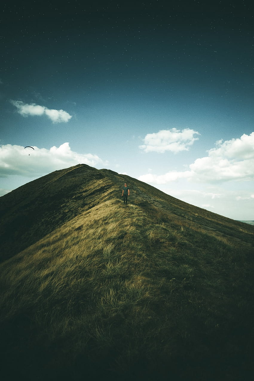 човек на планина със зелена трева – национален парк Peak District HD тапет за телефон