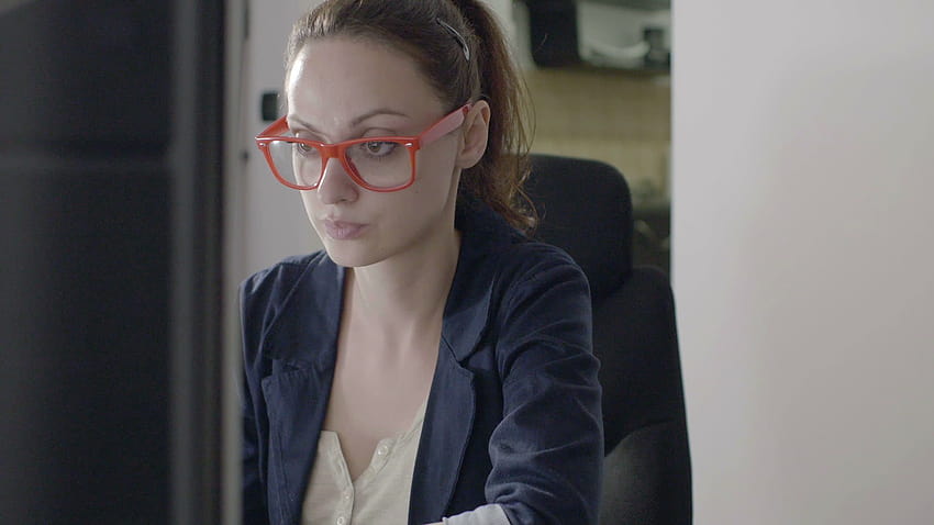 Bizneswoman siedzi przy biurku w biurze startowym high tech, pracując na komputerze Tapeta HD