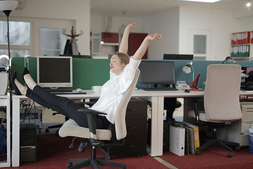 Trabalhadora de escritório relaxando com os pés na mesa · Estoque papel de parede HD