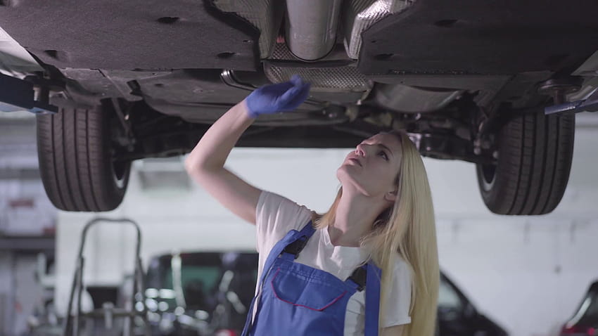 Camera moving around young blond Caucasian auto mechanic checking bottom of automobile. Serious woman working in car repair shop. Warranty service, profession. Stock Video Footage 00:07 SBV, mechanic women HD wallpaper