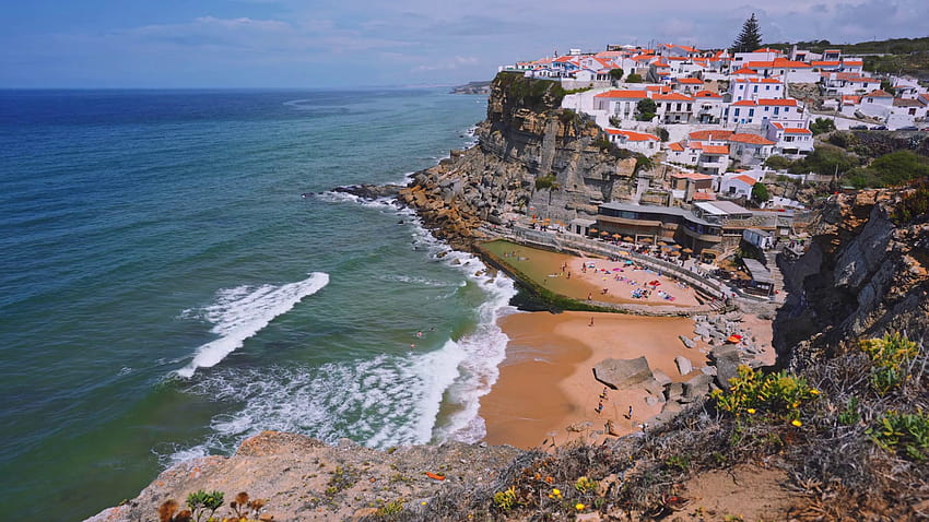view of the que village Azenhas do Mar. Chalk buildings on the edge of a cliff and beach below with white ocean waves moving. Sintra Landmark, Portugal, Europe Stock Video Footage HD wallpaper