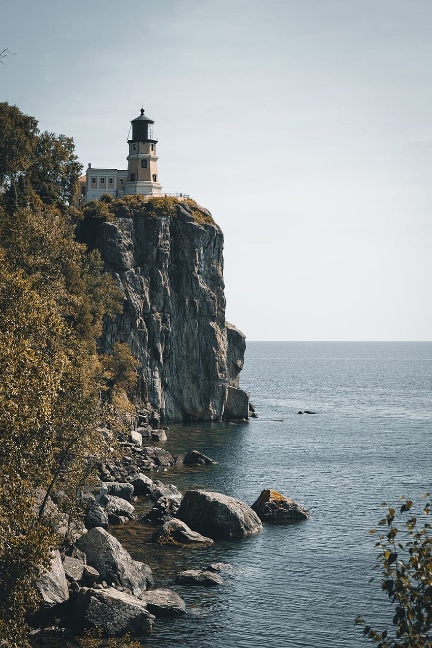 lighthouse above cliff near seashore – Beacon, rocky cliff lighthouse HD phone wallpaper