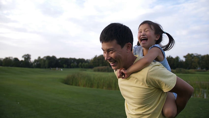Cheerful asian father giving his cute laughing preschool daughter piggyback ride while having fun in summer park. Adorable little chinese girl enjoying piggyback ride with her smiling dad outdoors. Stock Video Footage HD wallpaper