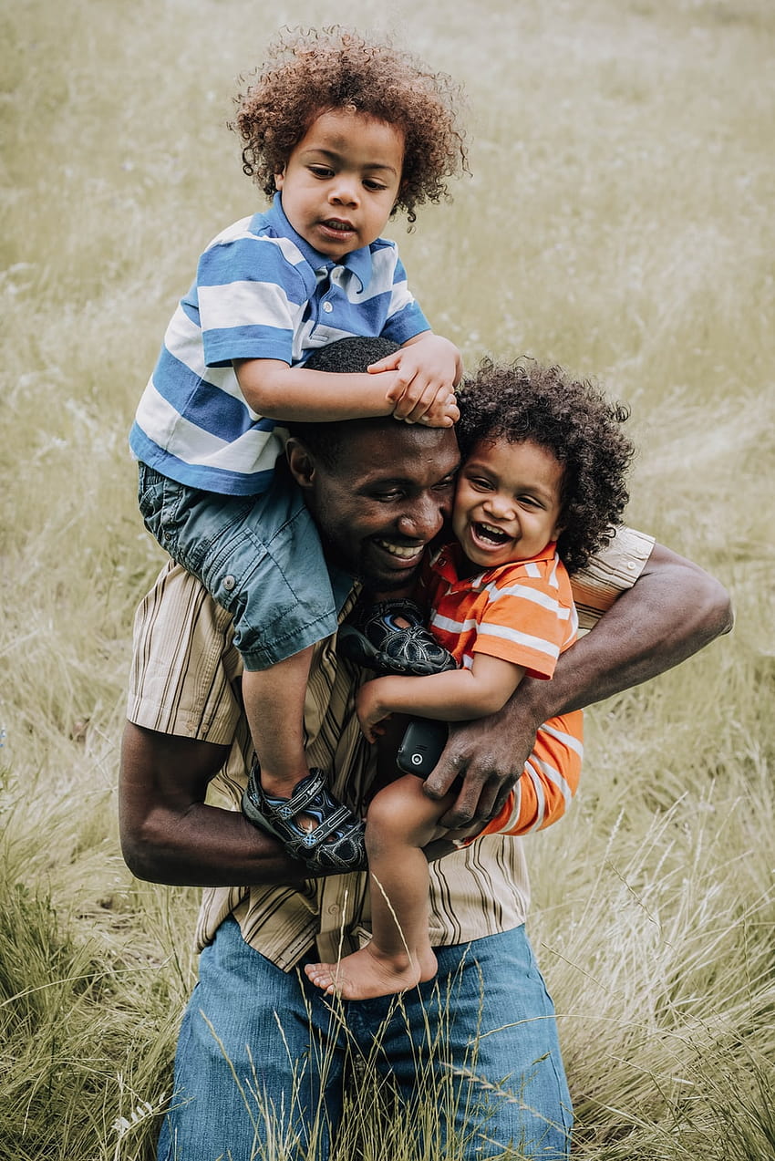 주황색과 검은색 캐리어에 아기를 안고 있는 파란색과 흰색 줄무늬 폴로 셔츠를 입은 남자 - 흑인 가족, 혼합 소년 HD 전화 배경 화면