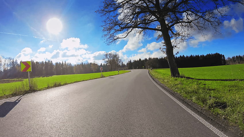 POV vehicle drive across beautiful countryside, local narrow road, green grassland, trees, shining sun blue sky, car travel gopro point of view Stock, countryside road trees and sunshine HD wallpaper