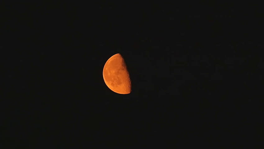 Orange waning gibbous moon against a black night sky Stock Video HD wallpaper