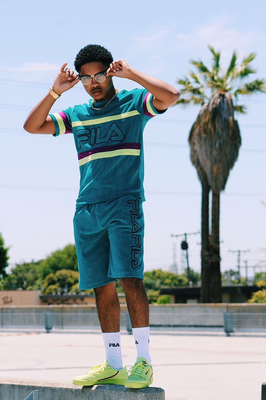Man in teal Fila shirt and shorts standing on concrete ground – Apparel ...