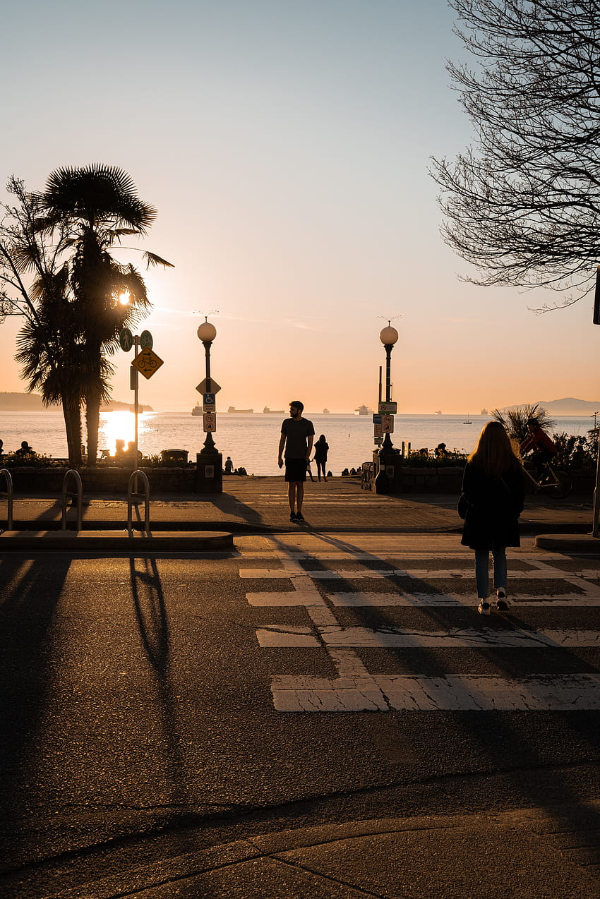 Silueta de gente caminando en la acera durante la puesta de sol en 2020 fondo de pantalla del teléfono