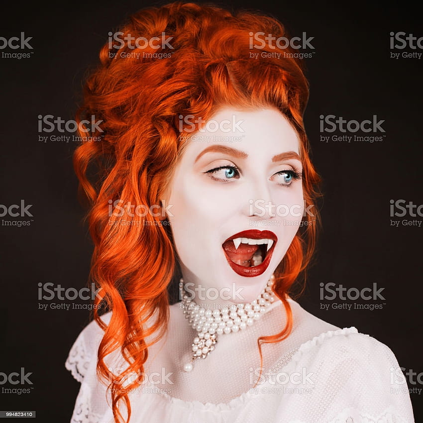 Young Vampire Woman With Long Curly Hair Pale Skin In A White Dress On A Black Backgrounds A Beautiful Redhead Model With Red Lips Outfit For Halloween Vampire With Open Mouth And HD phone wallpaper